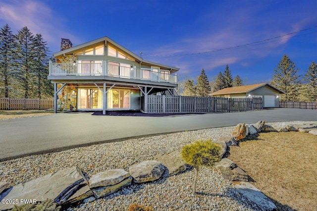 view of front of property featuring a chimney, a deck, and fence