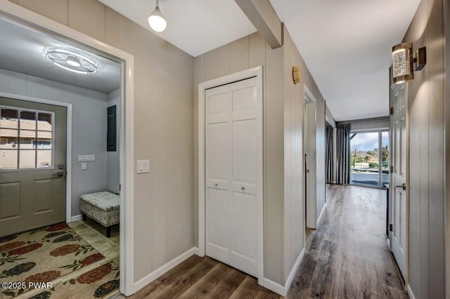 hallway with dark wood-type flooring and baseboards