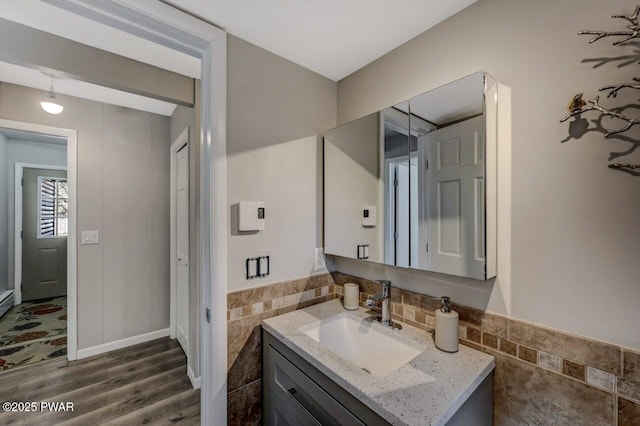 bathroom with vanity, tile walls, and wood finished floors