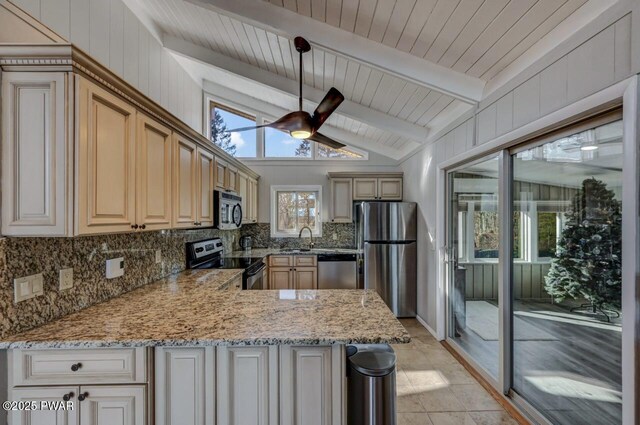 kitchen with lofted ceiling with beams, tasteful backsplash, stainless steel appliances, a peninsula, and light stone countertops