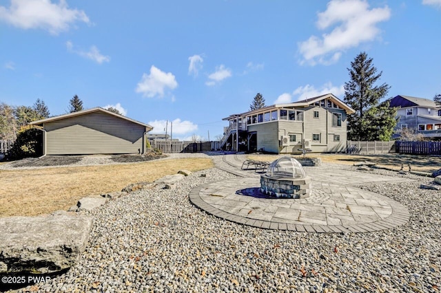 back of house with stairway, a patio, an outdoor fire pit, and fence