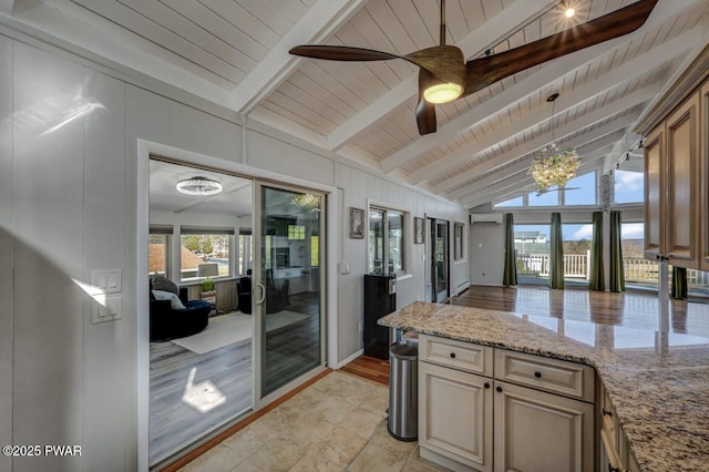 kitchen featuring lofted ceiling with beams, light stone countertops, a peninsula, and wooden ceiling