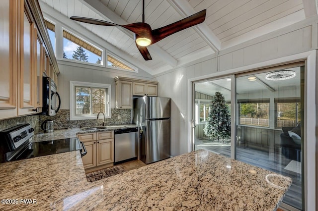 kitchen with a ceiling fan, a sink, backsplash, stainless steel appliances, and light stone countertops