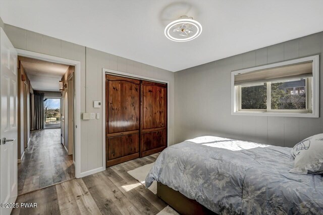 bedroom featuring wood finished floors, a closet, and baseboards