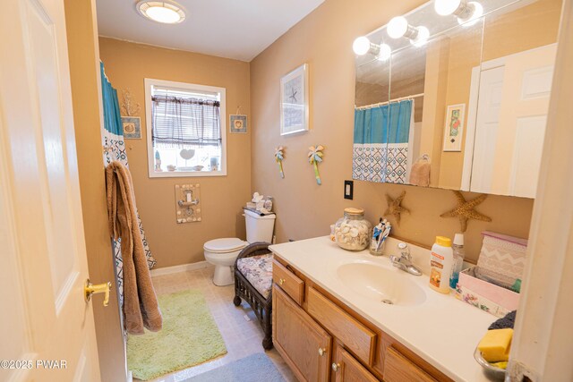 full bathroom with toilet, baseboards, a shower with shower curtain, and vanity