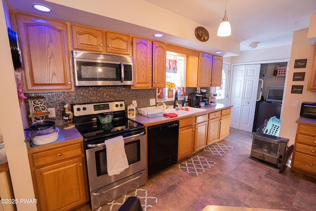 kitchen with hanging light fixtures, tasteful backsplash, stainless steel appliances, and a sink