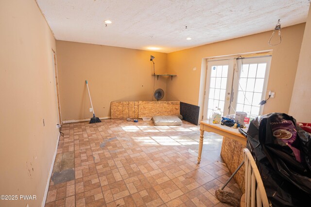 interior space featuring baseboards, a textured ceiling, and recessed lighting