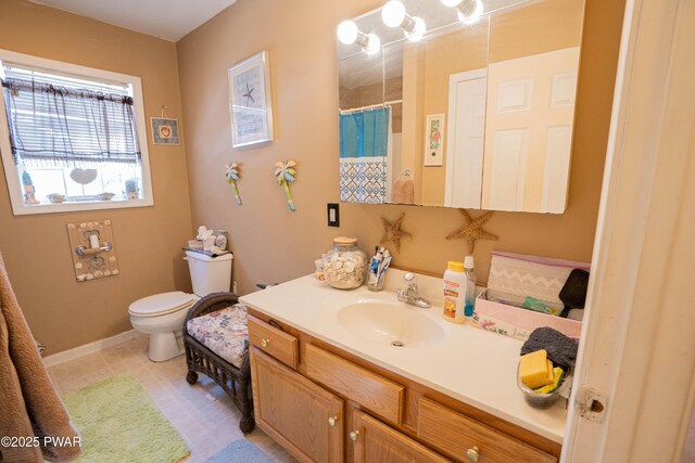 bathroom with a shower with curtain, baseboards, vanity, and toilet