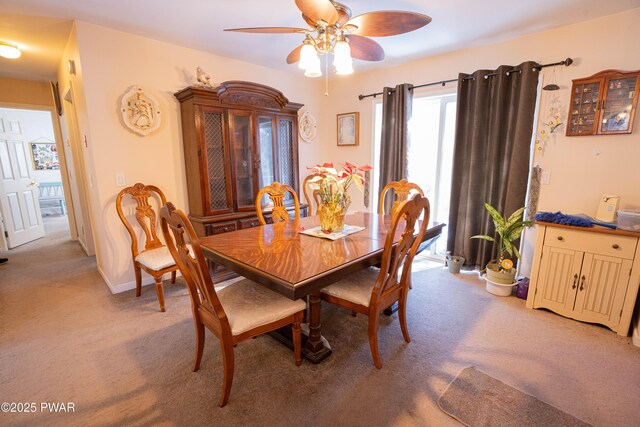 dining space featuring ceiling fan, baseboards, and light colored carpet