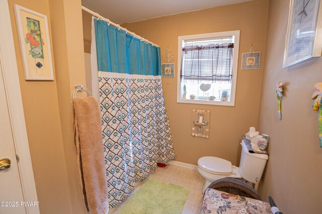 full bathroom with a shower with shower curtain, tile patterned flooring, baseboards, and toilet