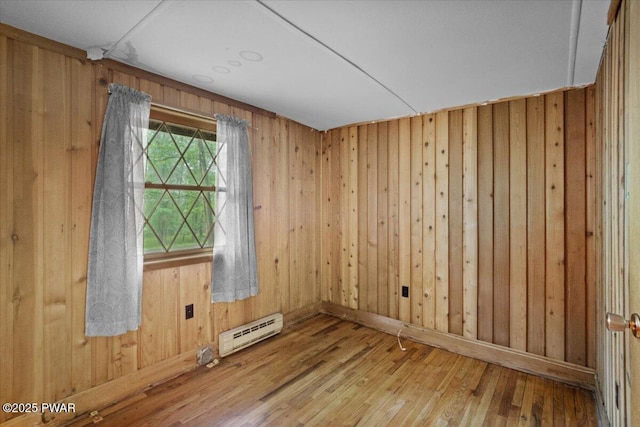 1081 Maple Lake Dr, Bushkill, PA 18324 - spare room with a baseboard radiator, hardwood / wood-style flooring, and wood walls