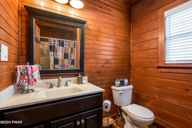 bathroom featuring a shower with curtain, wood walls, vanity, and toilet