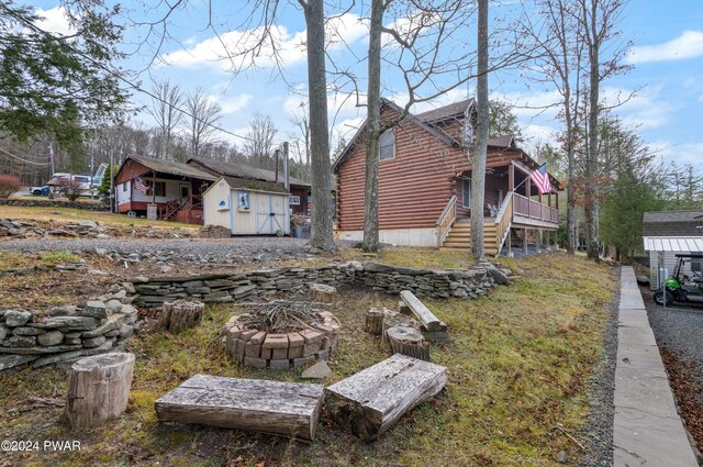 view of yard with a shed and a fire pit