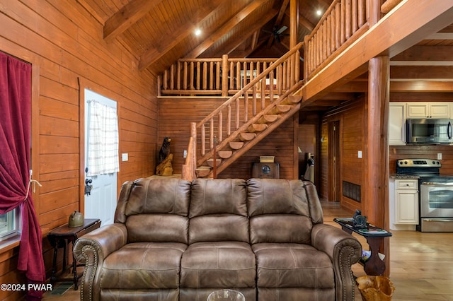 living room with beam ceiling, wooden ceiling, and wood walls