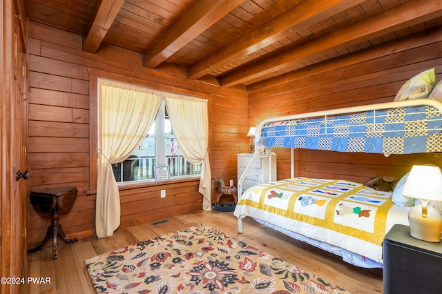 bedroom featuring wood walls, wood ceiling, beam ceiling, and light hardwood / wood-style flooring