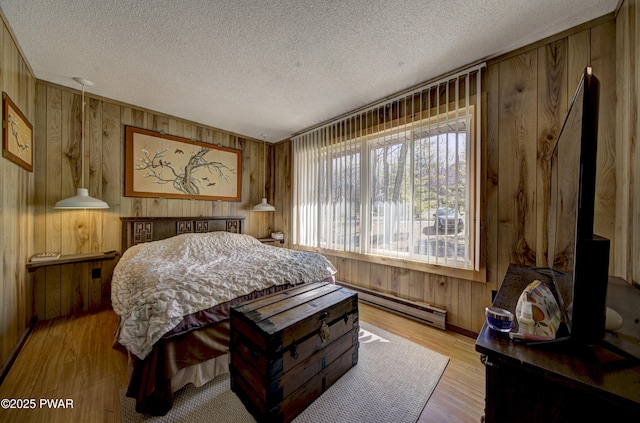 109 Pebble Rock Rd, Lackawaxen, PA 18435 - bedroom featuring a baseboard radiator, wood finished floors, wood walls, and a textured ceiling