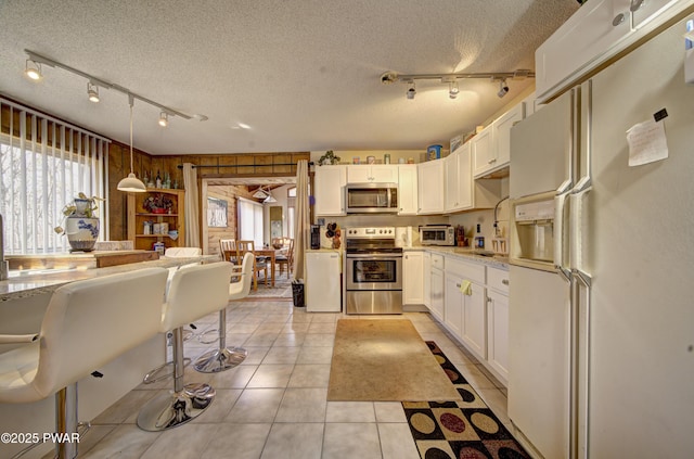 109 Pebble Rock Rd, Lackawaxen, PA 18435 - kitchen featuring light tile patterned flooring, a sink, white cabinetry, a textured ceiling, and stainless steel appliances