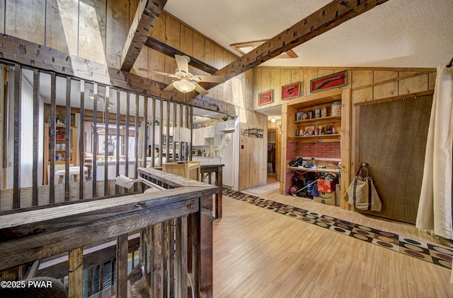 109 Pebble Rock Rd, Lackawaxen, PA 18435 - interior space with lofted ceiling with beams, a textured ceiling, wooden walls, ceiling fan, and wood finished floors
