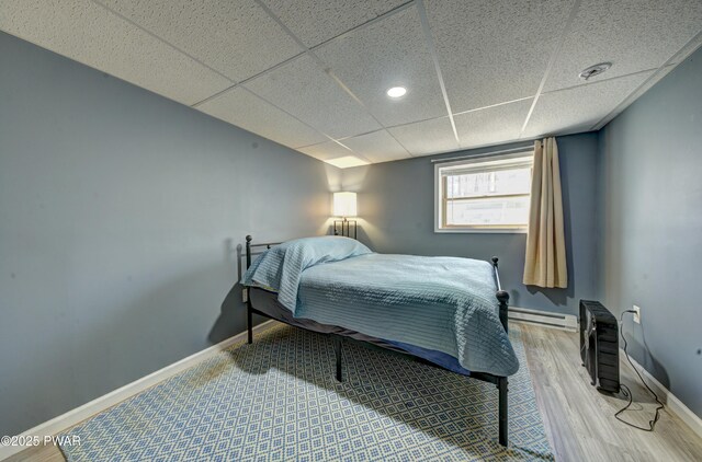 109 Pebble Rock Rd, Lackawaxen, PA 18435 - bedroom featuring baseboards, baseboard heating, wood finished floors, and a paneled ceiling