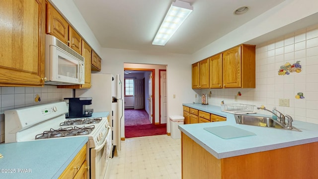 kitchen with white appliances, light floors, a sink, light countertops, and brown cabinets