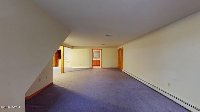 carpeted empty room featuring baseboard heating, baseboards, and visible vents