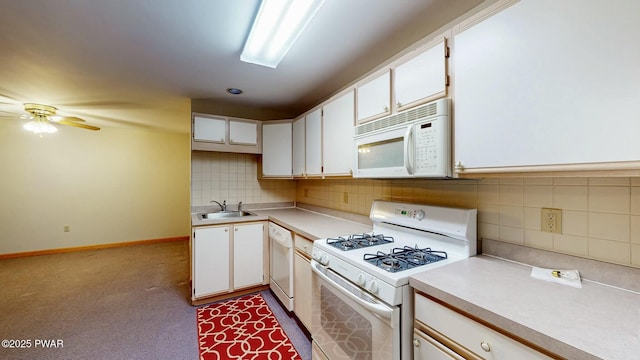 kitchen with white appliances, white cabinetry, light countertops, and a sink