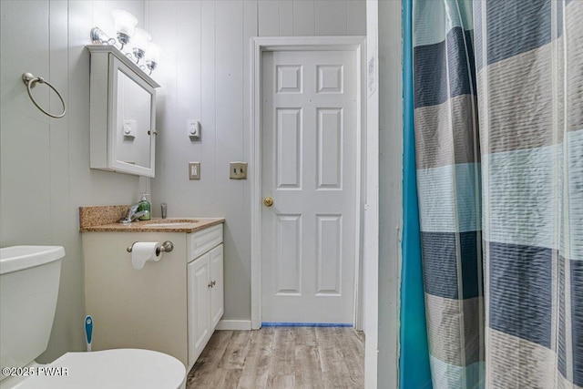 full bathroom featuring toilet, a shower with curtain, wood finished floors, and vanity