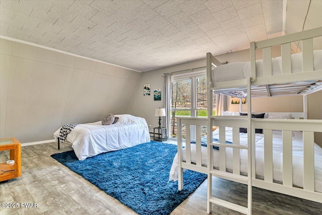 bedroom with baseboards and wood finished floors