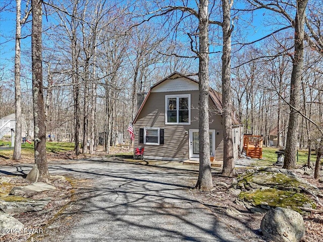 exterior space featuring driveway and a gambrel roof