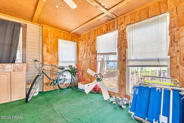 game room with carpet floors, wood walls, and a ceiling fan