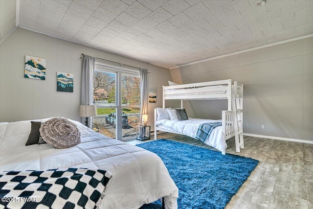 bedroom with crown molding, baseboards, and wood finished floors