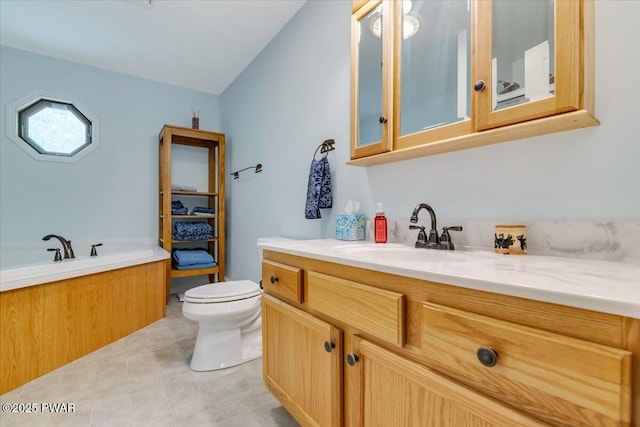 bathroom with toilet, vanity, a bath, and tile patterned floors