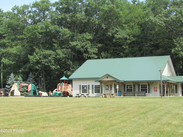 view of front of house with a playground, a front yard, and metal roof