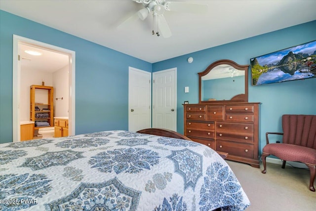 carpeted bedroom with a ceiling fan, ensuite bath, and a closet