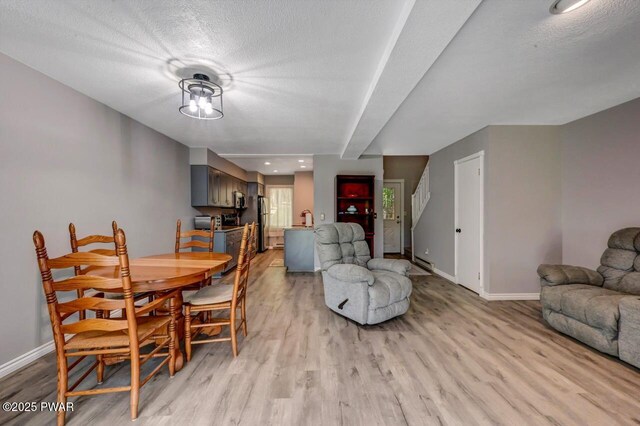 1107 Crest Cir, Lakeville, PA 18438 - dining space featuring baseboards, light wood-type flooring, beamed ceiling, and a textured ceiling