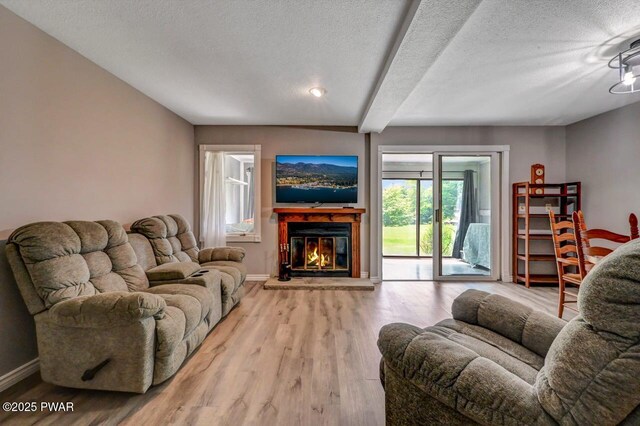 1107 Crest Cir, Lakeville, PA 18438 - living room with a glass covered fireplace, baseboards, wood finished floors, a textured ceiling, and beamed ceiling