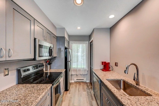 1107 Crest Cir, Lakeville, PA 18438 - kitchen with appliances with stainless steel finishes, a sink, a baseboard heating unit, light wood finished floors, and light stone counters