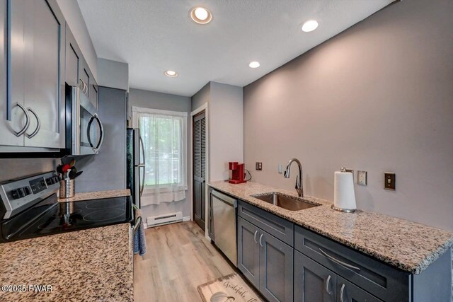 1107 Crest Cir, Lakeville, PA 18438 - kitchen with appliances with stainless steel finishes, a sink, a baseboard radiator, light wood-style flooring, and light stone counters