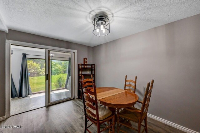 1107 Crest Cir, Lakeville, PA 18438 - dining space with wood finished floors, baseboards, and a textured ceiling