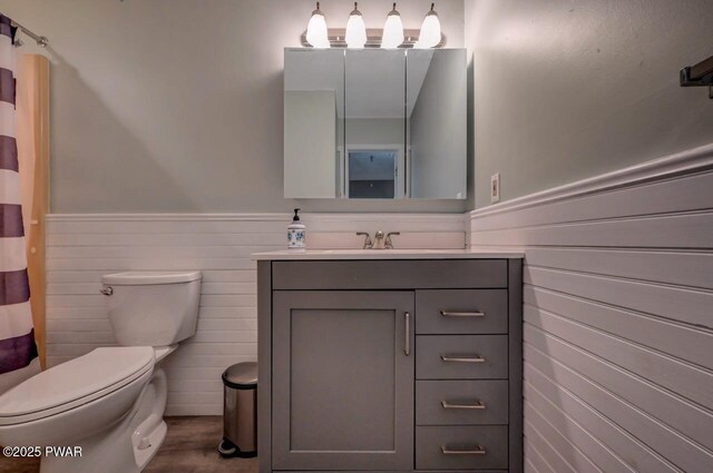 1107 Crest Cir, Lakeville, PA 18438 - bathroom featuring a wainscoted wall, toilet, vanity, wooden walls, and wood finished floors
