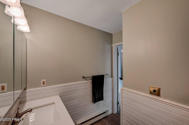 1107 Crest Cir, Lakeville, PA 18438 - bathroom with a baseboard heating unit, a wainscoted wall, a sink, and wood finished floors