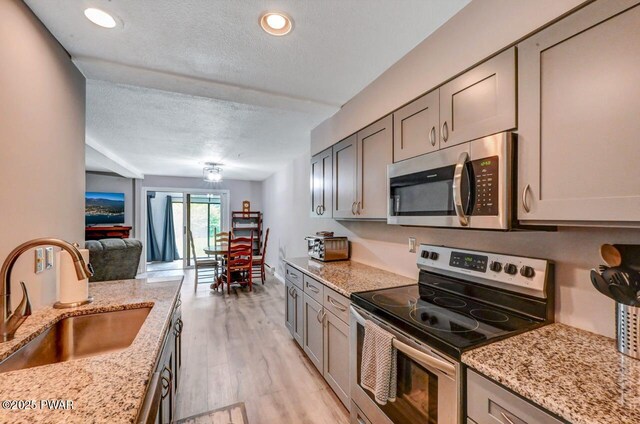 1107 Crest Cir, Lakeville, PA 18438 - kitchen with stainless steel appliances, a sink, gray cabinets, light wood-type flooring, and open floor plan