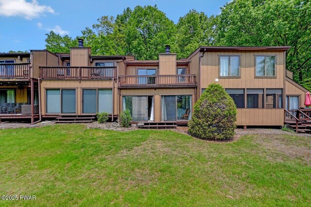 1107 Crest Cir, Lakeville, PA 18438 - back of house featuring a chimney, a lawn, and a wooden deck
