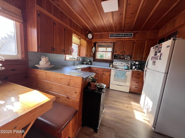 kitchen with white appliances, wooden ceiling, light hardwood / wood-style floors, kitchen peninsula, and sink