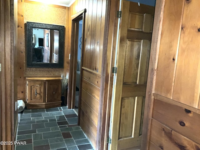 corridor featuring wooden walls and crown molding