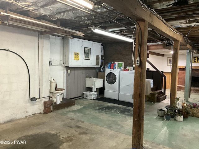 basement with washer and clothes dryer and sink