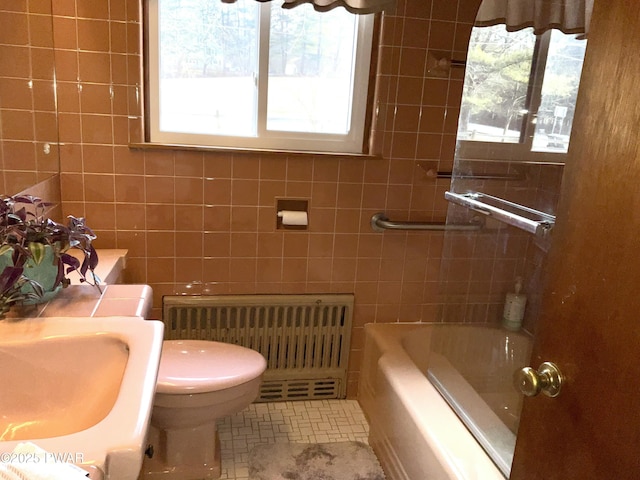 full bathroom with sink, tile patterned flooring, tile walls, radiator, and toilet