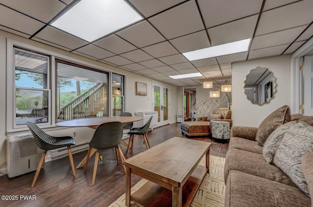 living room featuring wood finished floors, healthy amount of natural light, and a drop ceiling
