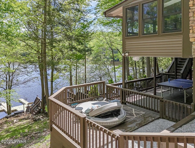 deck with stairway and a water view