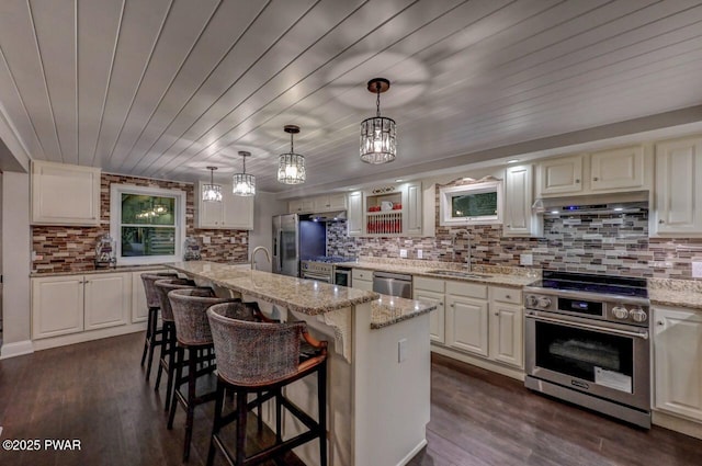 kitchen featuring appliances with stainless steel finishes, a sink, tasteful backsplash, light stone countertops, and wooden ceiling